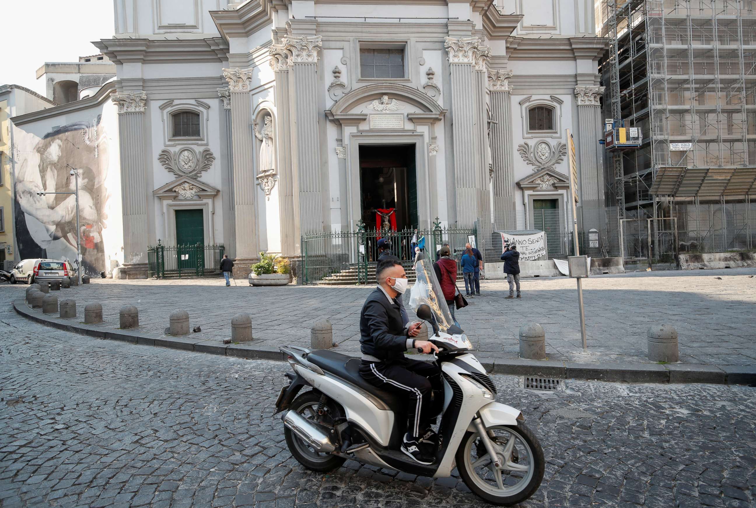 PHOTO: A man wearing a protective mask sits on a scooter in Naples, Italy, April 10, 2020.