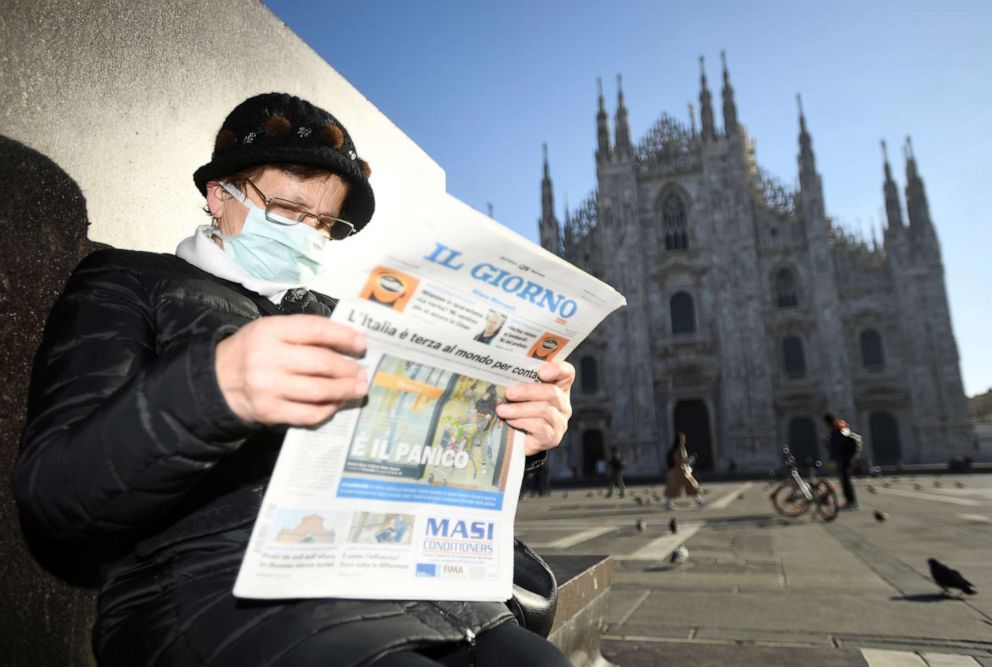PHOTO: A woman reads a newspaper outside Duomo cathedral, closed by authorities due to a coronavirus outbreak, in Milan, Italy, Feb. 24, 2020.