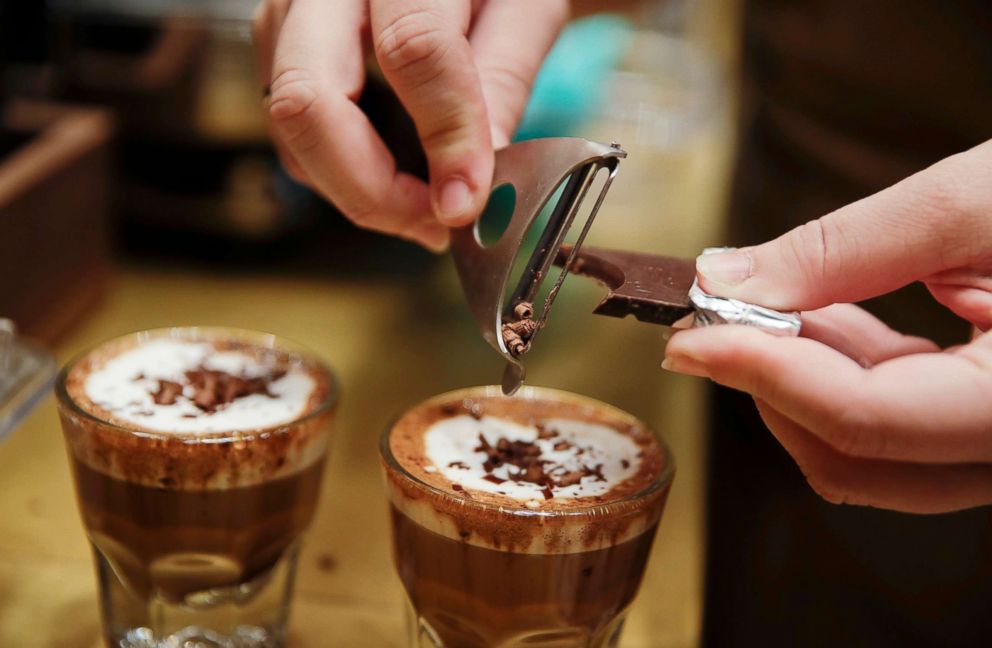 PHOTO: A waiter adds chocolate to coffee cups, at the Starbucks store in Milan, Sept. 4, 2018.