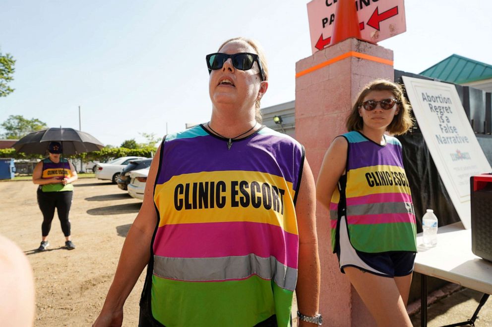 Clinic escort Kim Gibson stands outside the driveway to the Jackson Women's Health Organization clinic in Jackson, Miss. as she shouts at anti-abortion opponents moments after the U.S. Supreme Court overturned Roe v. Wade, June 24, 2022.