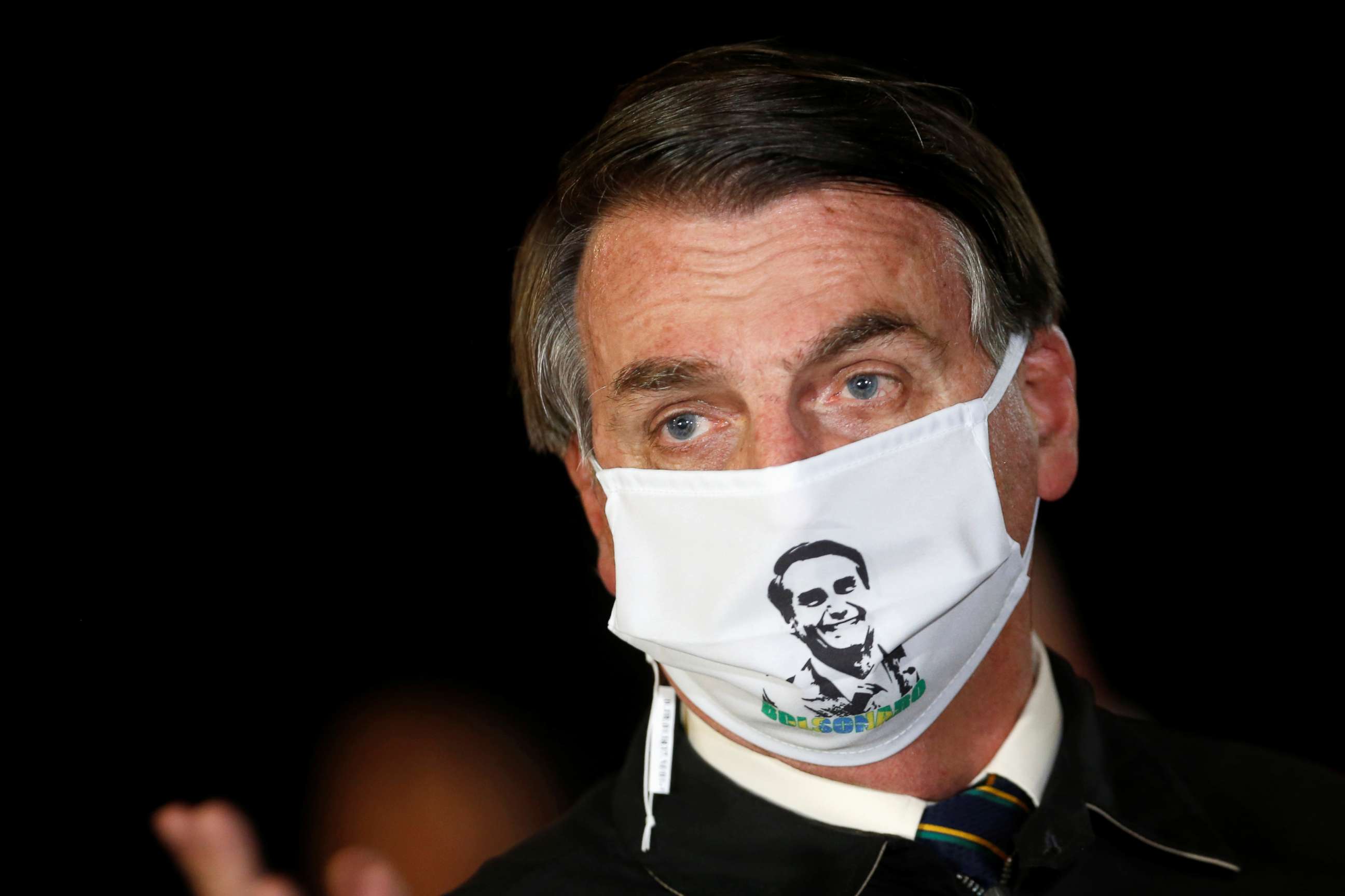 PHOTO: Brazil's President Jair Bolsonaro speaks with journalists while wearing a protective face mask as he arrives at Alvorada Palace, amid the coronavirus disease outbreak, in Brasilia, Brazil, May 22, 2020.