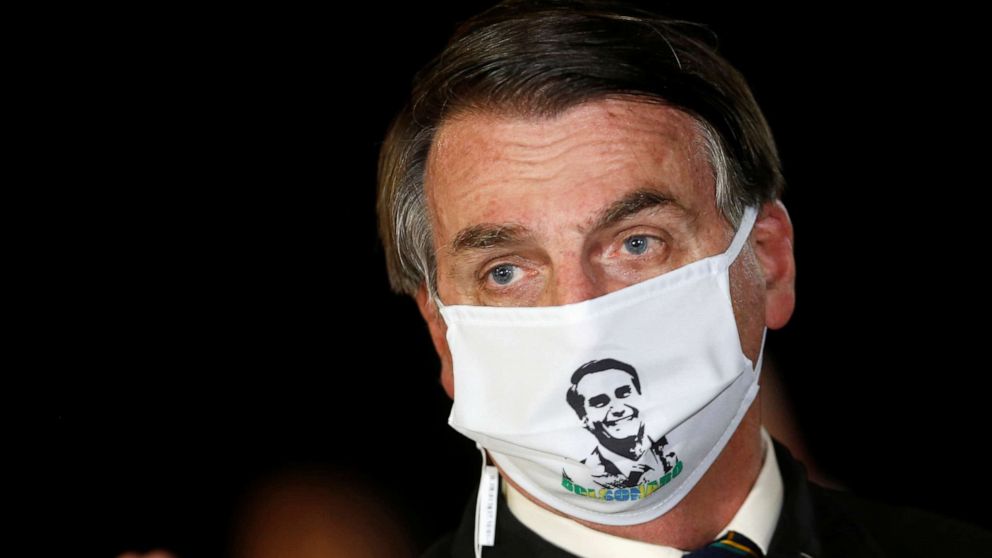PHOTO: Brazil's President Jair Bolsonaro speaks with journalists while wearing a protective face mask as he arrives at Alvorada Palace, amid the coronavirus disease outbreak, in Brasilia, Brazil, May 22, 2020.