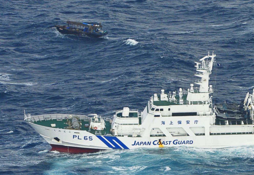 PHOTO: A wooden boat, top, is seen near a patrol ship of Japan Coast Guard off Matsumae, Hokkaido, Japan, Nov. 29, 2017. 