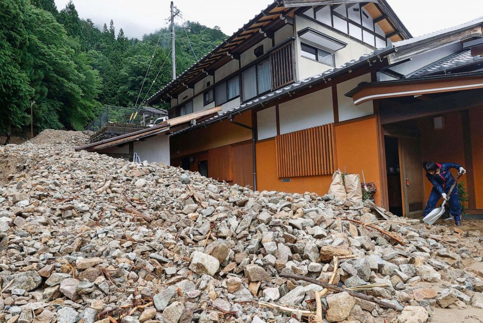 PHOTO: A resident cleans earth and sand that slid into the front of a house following a heavy rain in Gero, Gifu prefecture, central Japan, July 9, 2020.