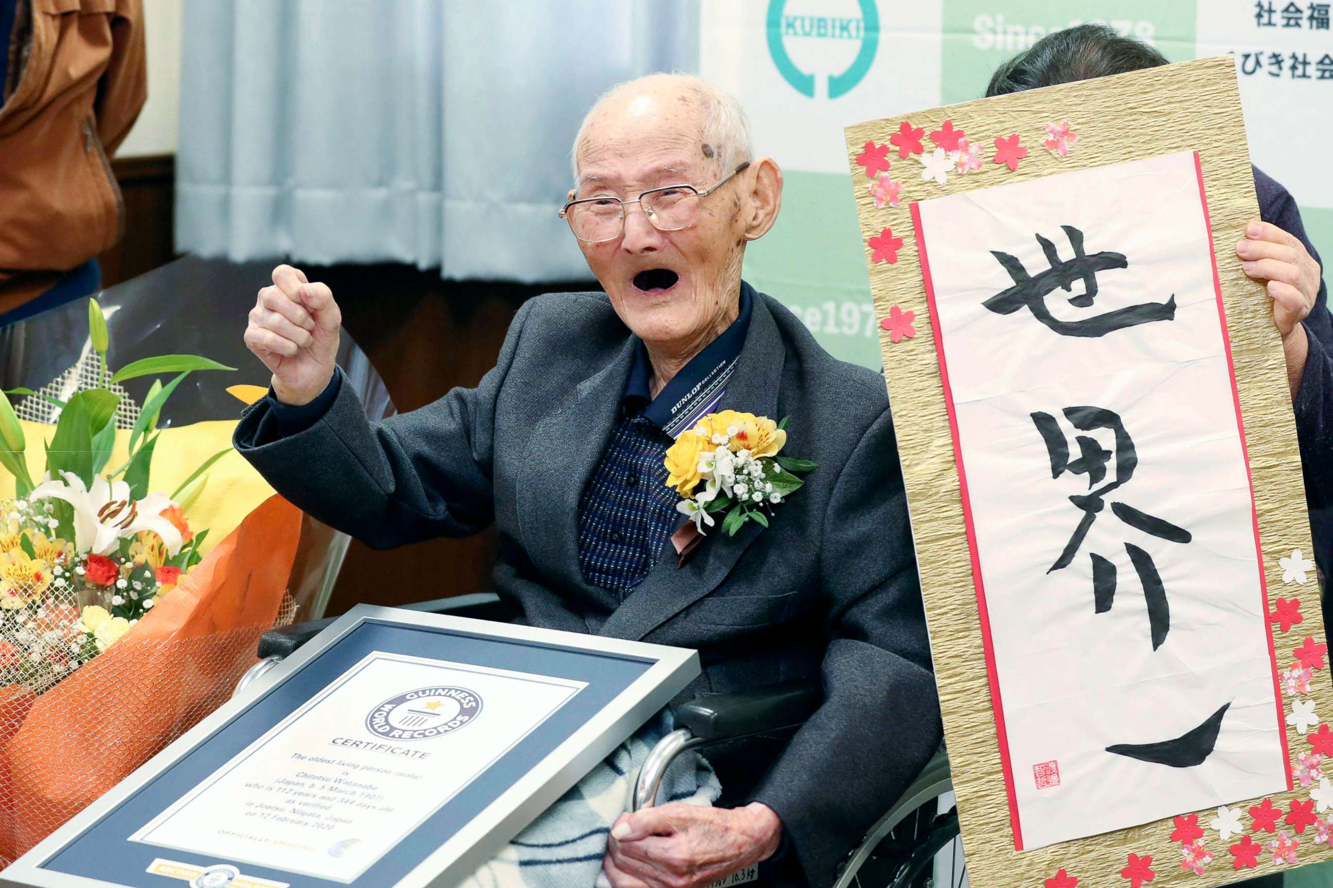 PHOTO: Chitetsu Watanabe, 112, poses next to the calligraphy he wrote after being awarded as the world's oldest living male by Guinness World Records, in Joetsu, Niigata prefecture, northern Japan Feb. 12, 2020.