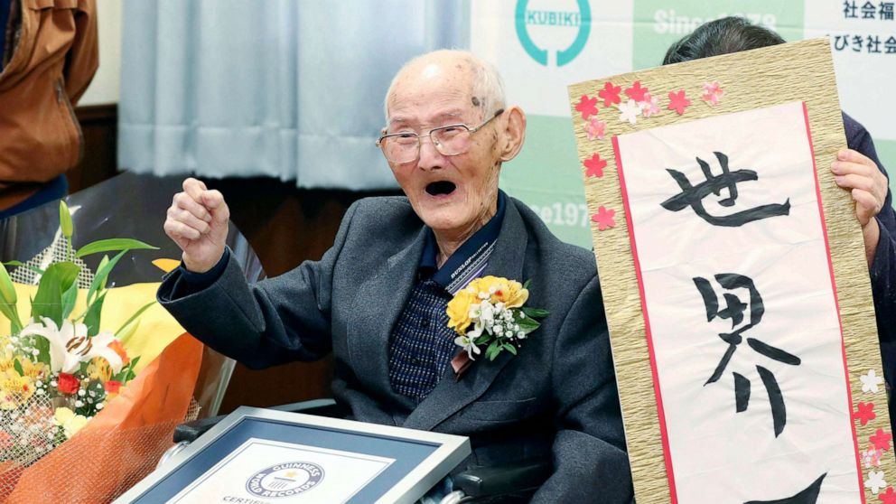 PHOTO: Chitetsu Watanabe, 112, poses next to the calligraphy he wrote after being awarded as the world's oldest living male by Guinness World Records, in Joetsu, Niigata prefecture, northern Japan Feb. 12, 2020.