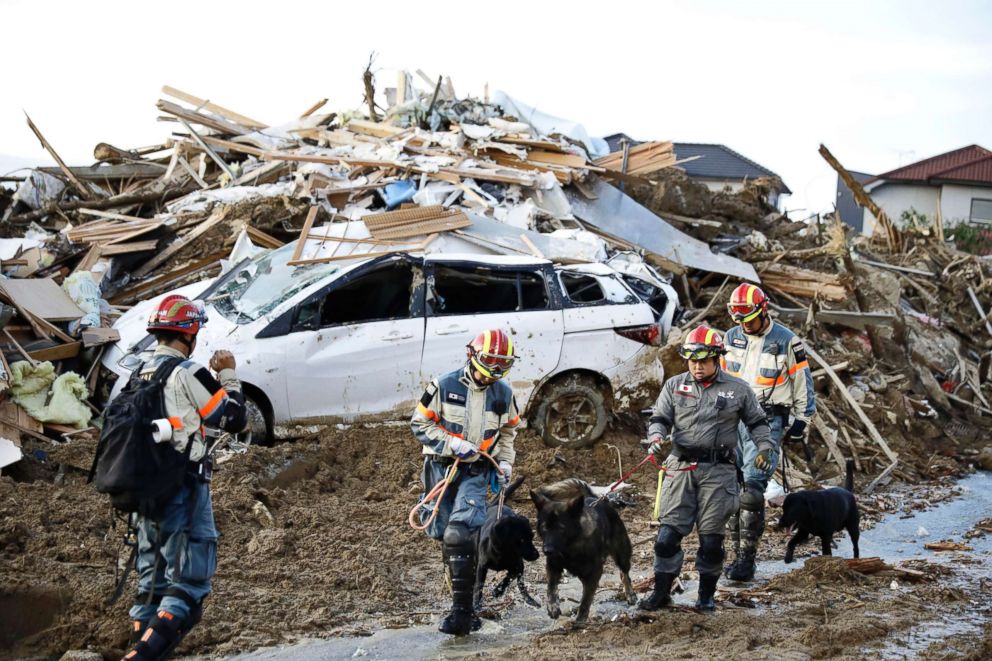 PHOTO: Firefighters with rescue dogs search for missing people after heavy rain hit southwestern Japan, in Kumano town, Hiroshima prefecture, July 9, 2018.