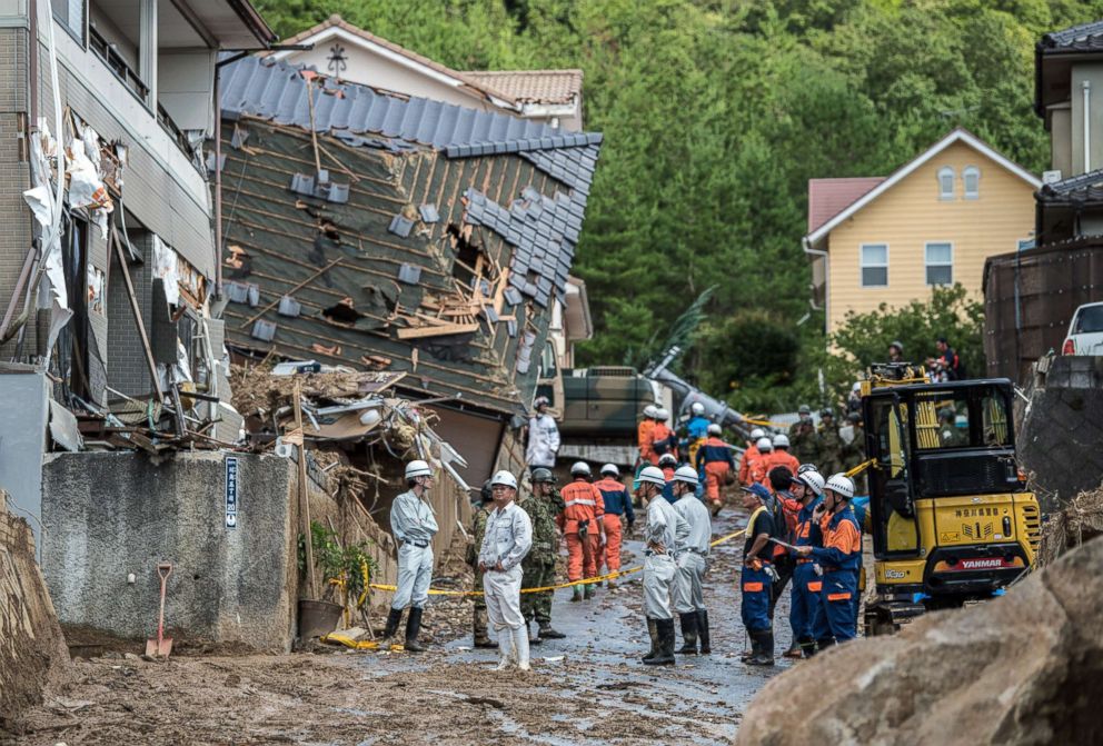 PHOTO: Emergency services members work next to houses destroyed by a landslide on July 8, 2018 in Kumano near Hiroshima, Japan.