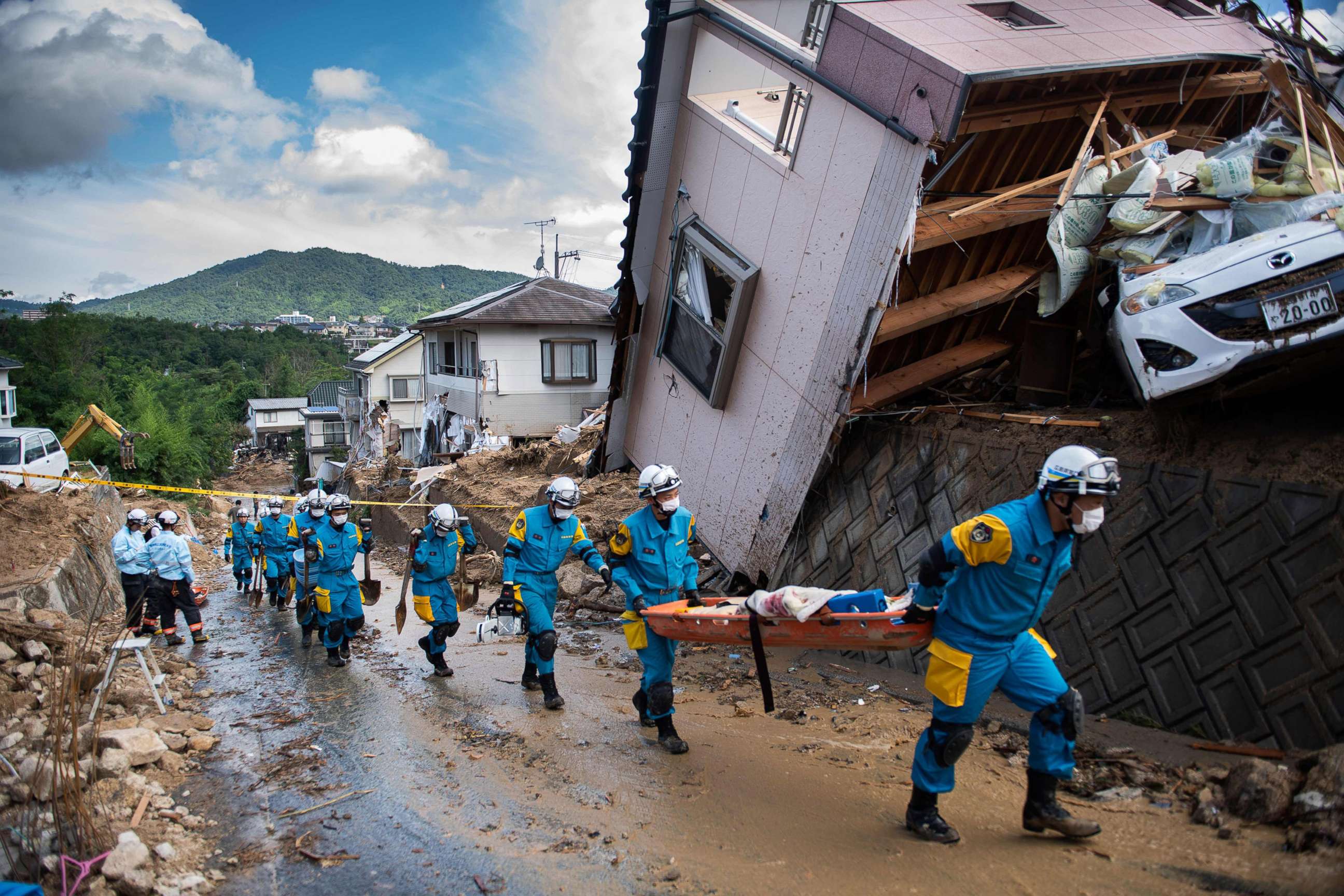 PHOTO: Police arrive to clear debris scattered on a street in a flood hit area in Kumano, Hiroshima prefecture on July 9, 2018.