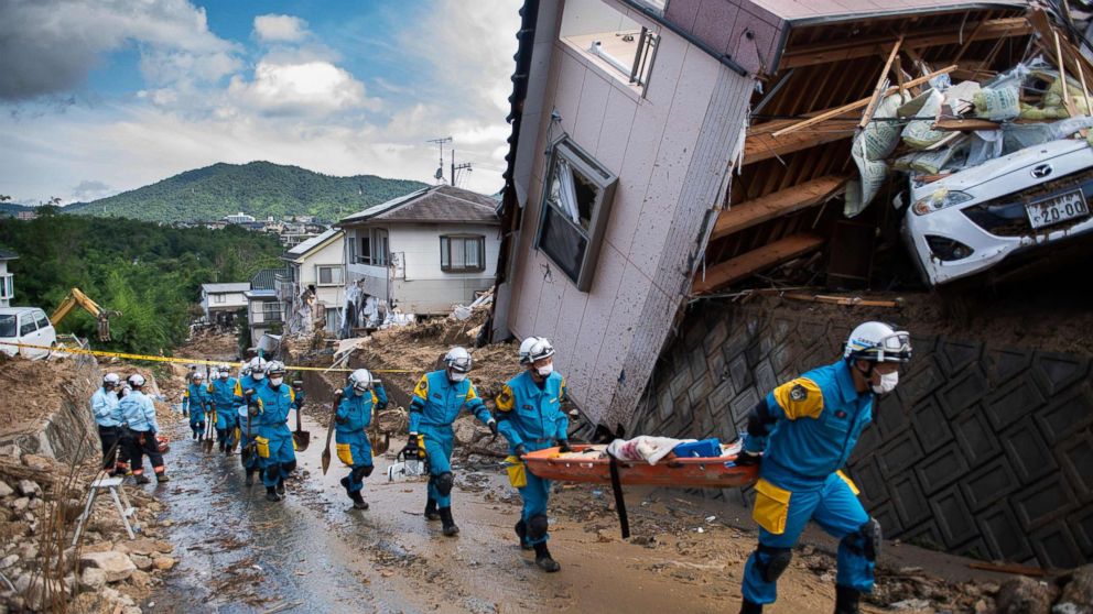 PHOTO: Police arrive to clear debris scattered on a street in a flood hit area in Kumano, Hiroshima prefecture on July 9, 2018.