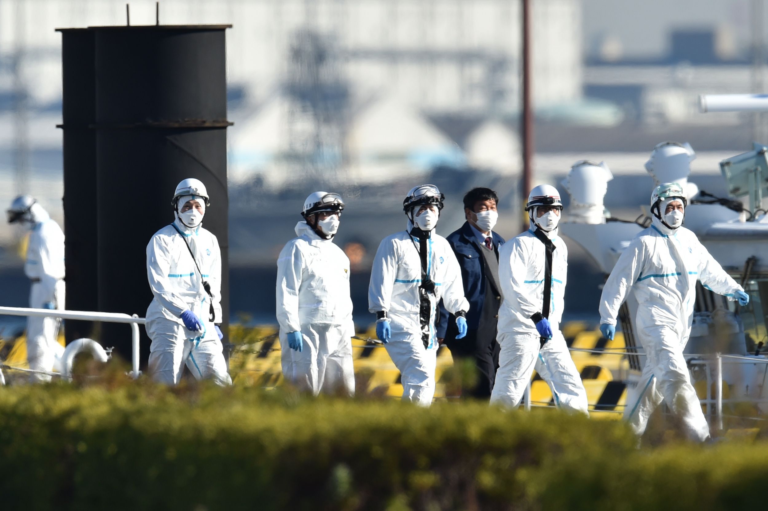 PHOTO: Personnel clad in protective gear, tasked to provide care for suspected coronavirus patients on board the Diamond Princess cruise ship, are seen at the Japan Coast Guard base in Yokohama on Feb. 5, 2020.