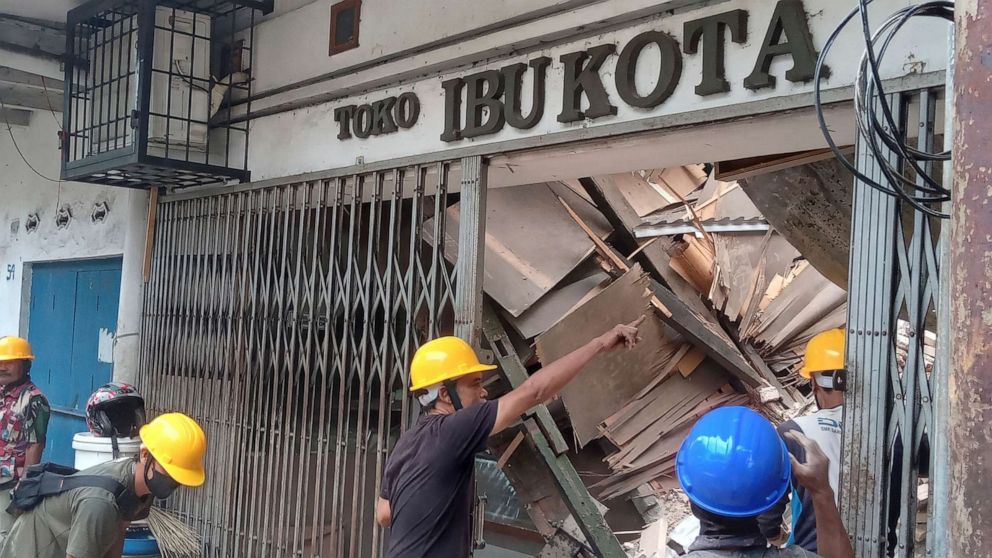 FOTO: Pekerja memeriksa toko yang rusak akibat gempa bumi di Cianjur, Jawa Barat, Indonesia, 21 November 2022.
