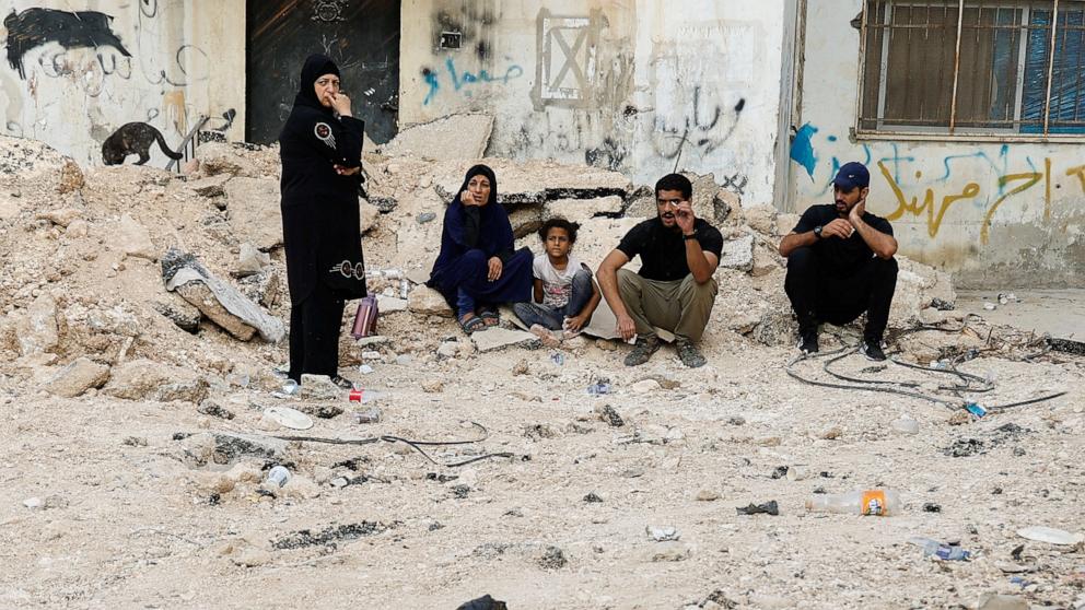 PHOTO: Palestinians sit by a damaged road, following a several day long Israeli-raid, in Jenin camp, in the Israeli-occupied West Bank, Sept. 6, 2024.