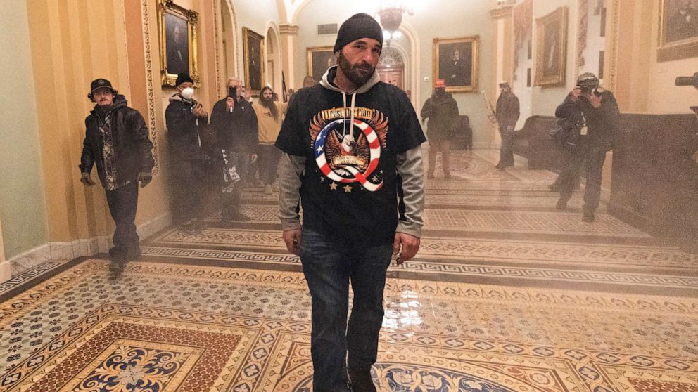 PHOTO: Smoke fills the walkway outside the Senate Chamber as supporters of President Donald Trump, including Douglas Jensen, center, are confronted by U.S. Capitol Police officers, Jan. 6, 2021, inside the Capitol in Washington.