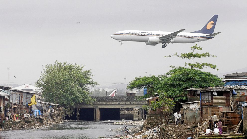 PHOTO: A Jet Airways plane flies over the Mithi River on its way to landing at Mumbai airport, at Bharat Nagar, Aug. 16, 2005 in Hyderabad, India.