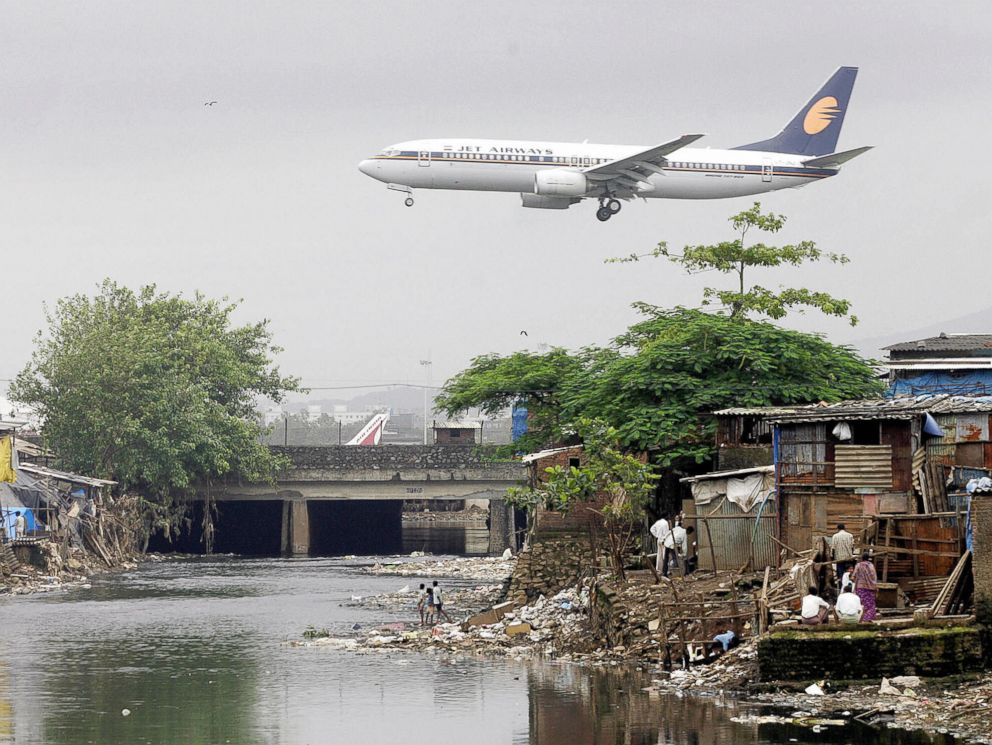 PHOTO: A Jet Airways plane flies over the Mithi River on its way to landing at Mumbai airport, at Bharat Nagar, Aug. 16, 2005 in Hyderabad, India.