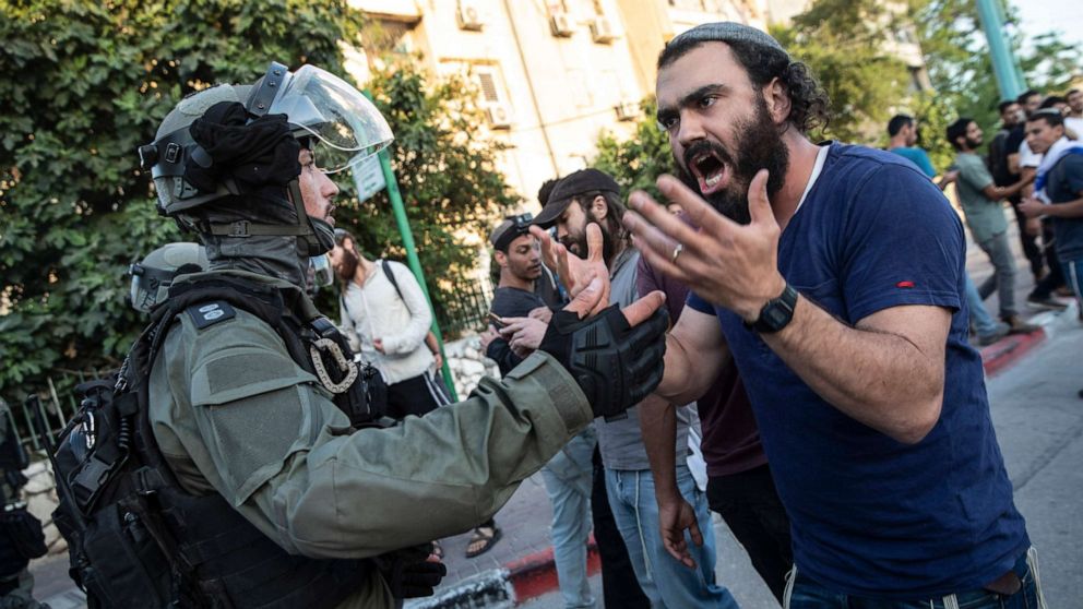 PHOTO: In this May 12, 2021, file photo, Israeli riot police tries to block a Jewish right-wing man as clashes erupted between Arabs, police and Jews, in the mixed town of Lod, central Israel.
