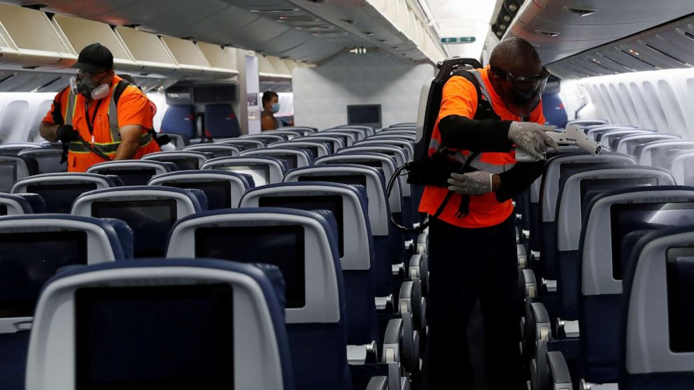 PHOTO: Delta Air Lines pre-flight cleaning crew members use electrostatic disinfection devices to clean an aircraft at JFK International Airport in New York, Aug. 6, 2020.