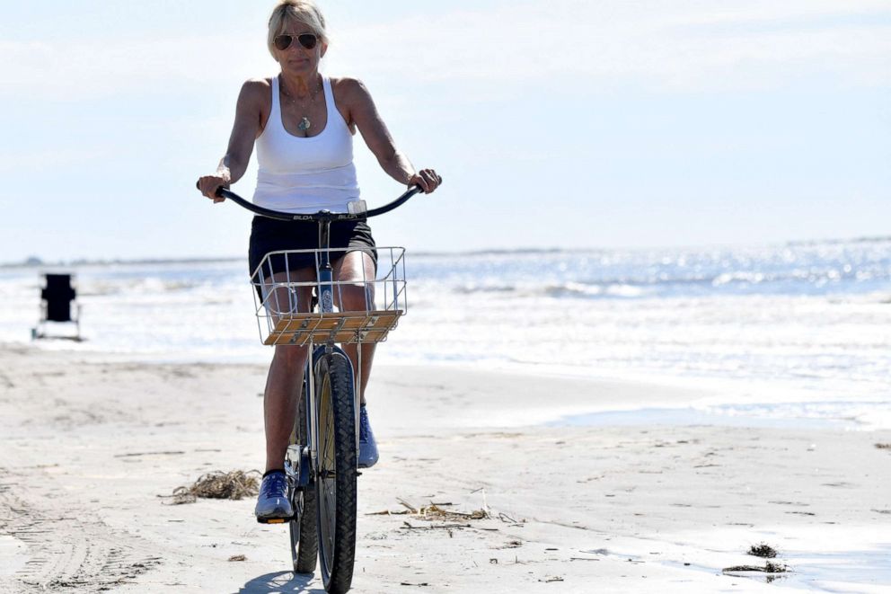 PHOTO: First Lady Jill Biden rides her bicycle along the beach while on vacation in Kiawah Island, S.C., Aug. 14, 2022.