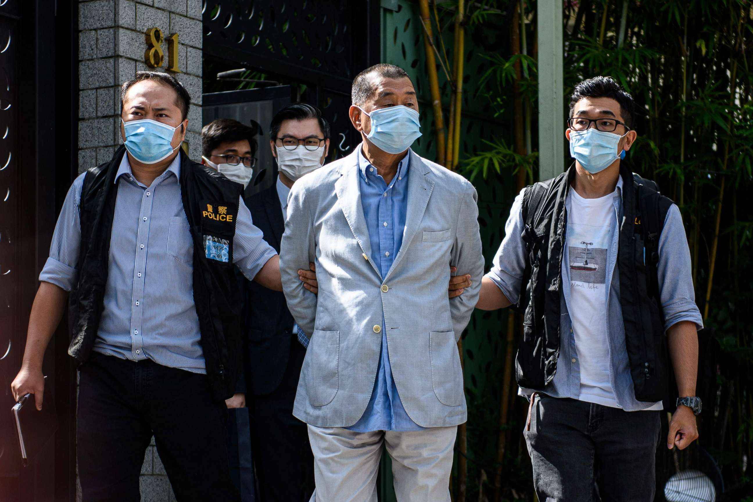 PHOTO: TOPSHOT - Police lead Hong kong pro-democracy media mogul Jimmy Lai (C), 72, away from his home after he was arrested under the new national security law in Hong kong on August 10, 2020. 