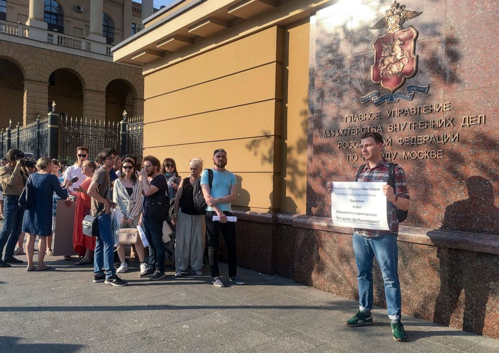 PHOTO: Colleagues and friends stand by as one stands alone in protest for detained journalist Ivan Golunov, at Russian Internal Ministry building in Moscow, June 7, 2019.