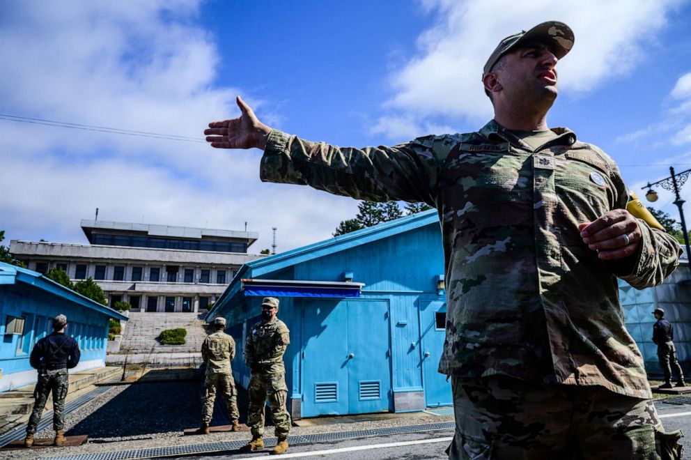 PHOTO: A United Nations Command soldier provides a media tour as a South Korean soldier and others stand guard before the military demarcation line separating North and South Korea, at the Joint Security Area in Panmunjom on October 4, 2022.