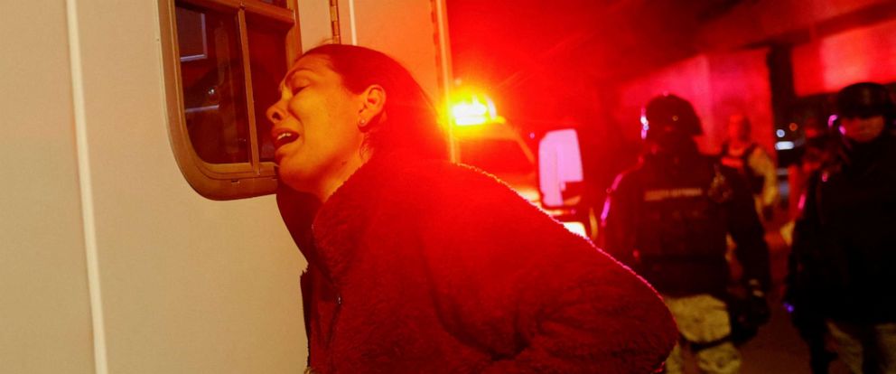 PHOTO: Viangly, a Venezuelan migrant, reacts outside an ambulance while Mexican authorities and firefighters remove injured migrants from inside the National Migration Institute building during a fire, in Ciudad Juarez, Mexico, March 27, 2023.