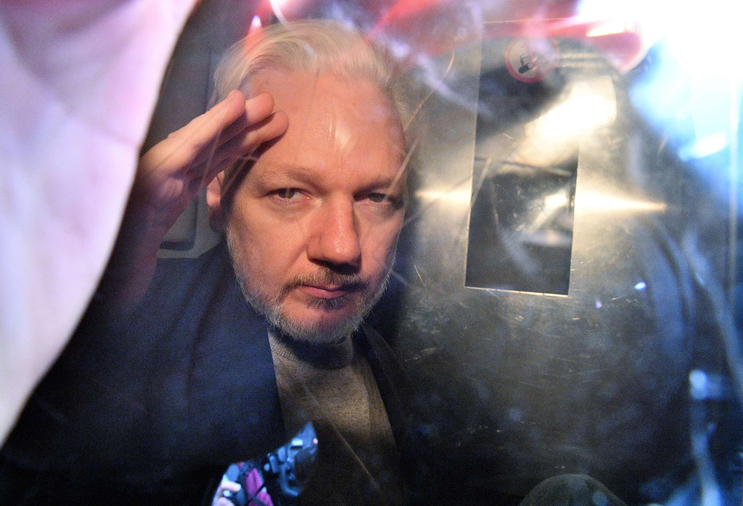 PHOTO: WikiLeaks founder Julian Assange gestures from the window of a prison van as he is driven out of Southwark Crown Court in London on May 1, 2019.