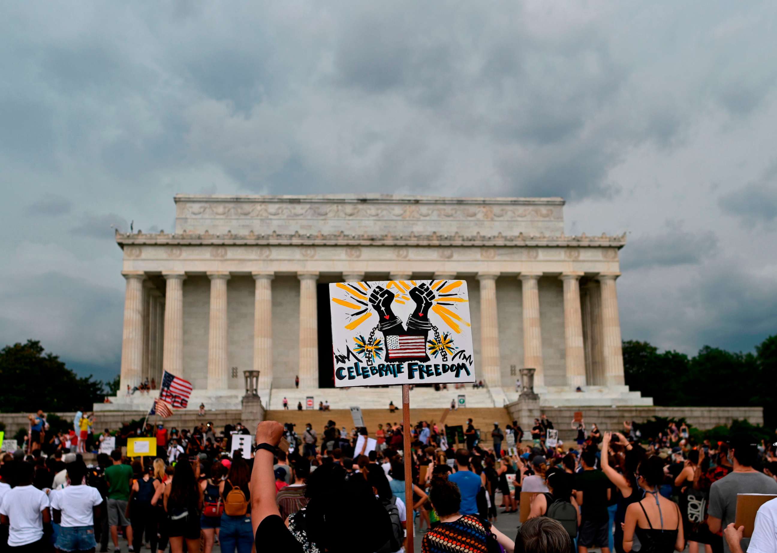 PHOTO: Demonstrators hold signs as they take part in a Juneteenth march and rally in front of the Lincoln Memorial, in Washington, June 19, 2020.