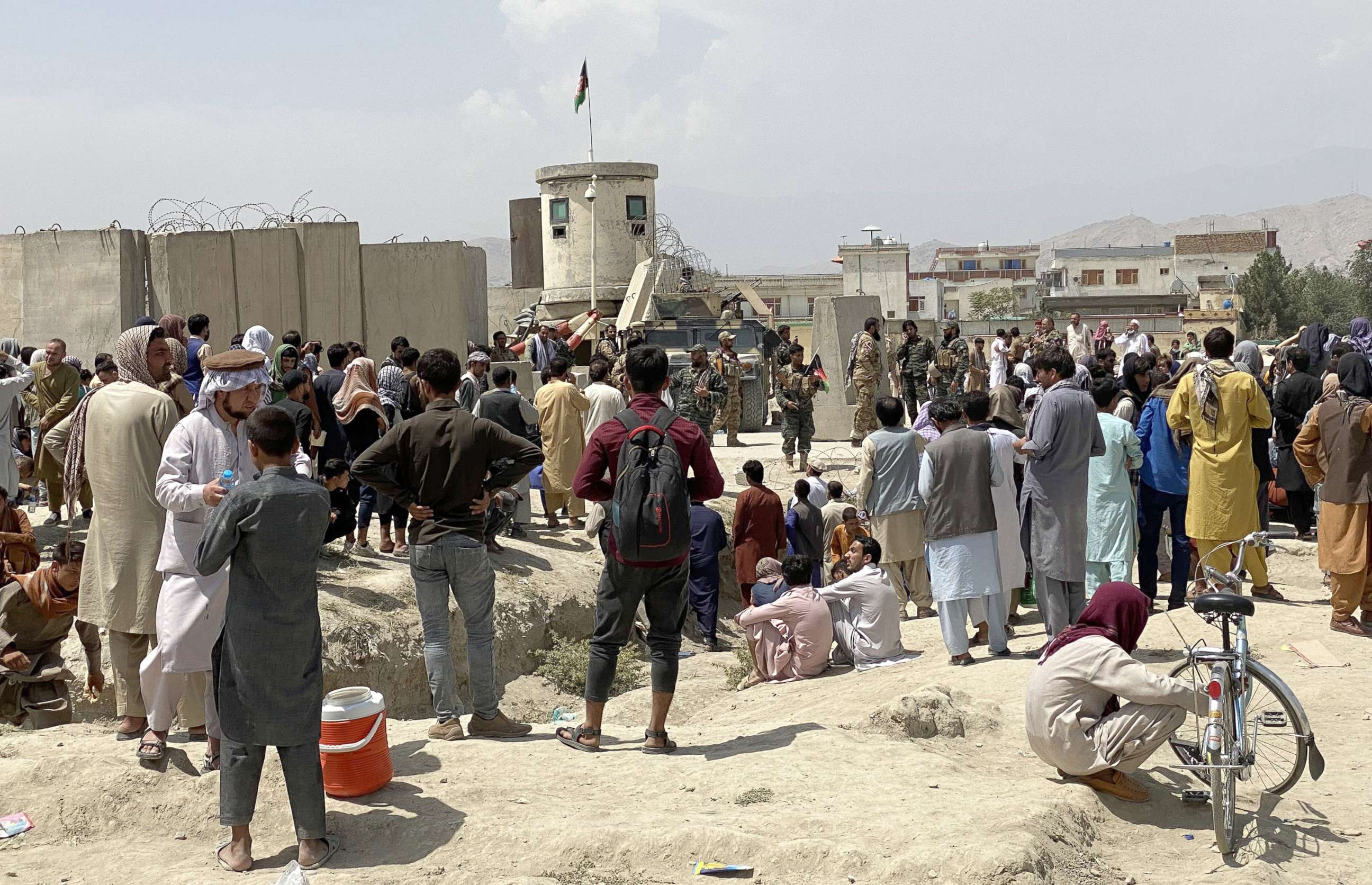 PHOTO: Afghans gather outside the Hamid Karzai International Airport to flee the country on 17 August 2021, after Taliban took control of Kabul.