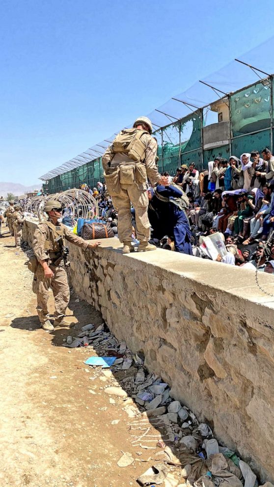 PHOTO: Security forces assist people struggling to flee the country outside the Abbey Gate at the Karzai International Airport, in Kabul, Aug. 25, 2021.