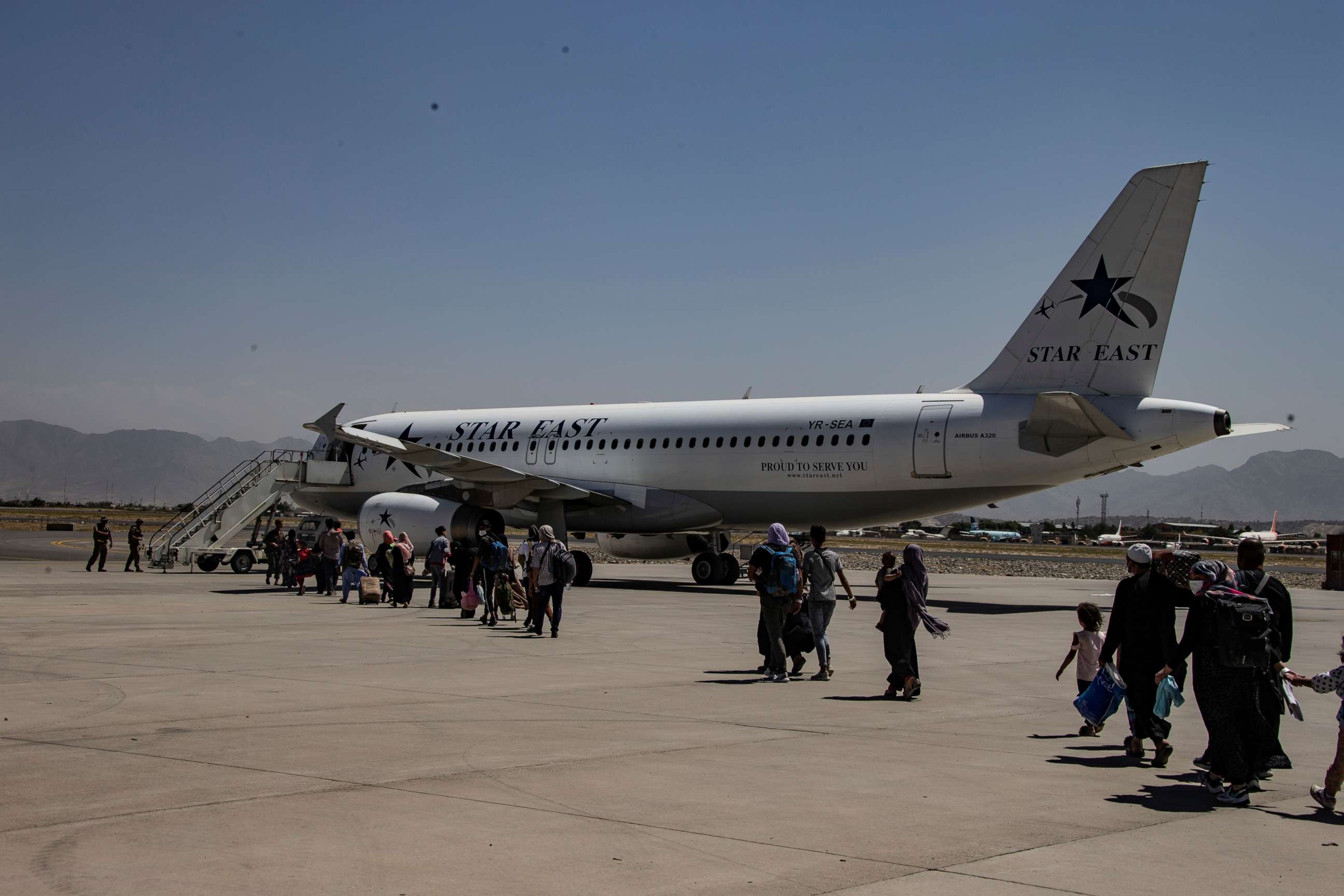 PHOTO: Evacuees are escorted to an aircraft during an evacuation at Hamid Karzai International Airport, Kabul, Afghanistan, Aug. 25, 2021. 