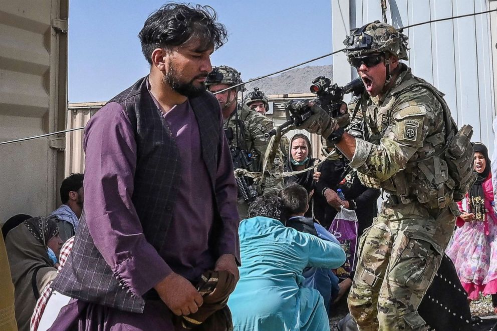 PHOTO: A U.S. soldier point his gun towards an Afghan passenger at the Kabul airport in Kabul on Aug. 16, 2021, as thousands of people mobbed the city's airport trying to flee the Taliban's feared hardline brand of Islamist rule.