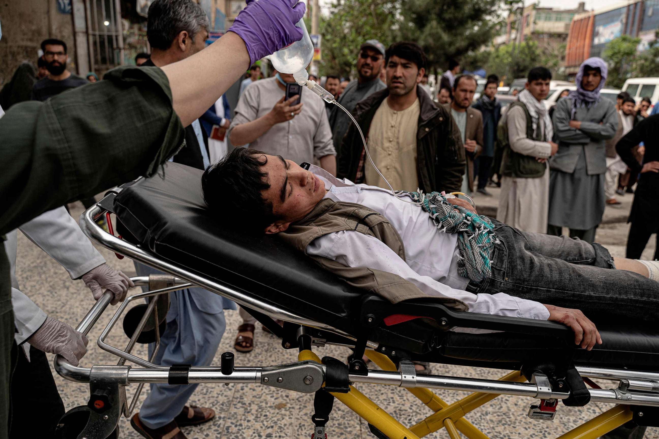 PHOTO: Medical staff move a wounded youth by stretcher outside a hospital in Kabul, April 19, 2022, after two bomb blasts rocked a boys' school in a Shiite Hazara neighborhood killing several.
