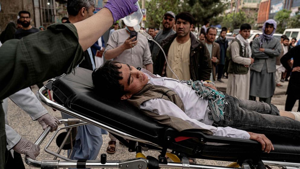 PHOTO: Medical staff move a wounded youth by stretcher outside a hospital in Kabul, April 19, 2022, after two bomb blasts rocked a boys' school in a Shiite Hazara neighborhood killing several.