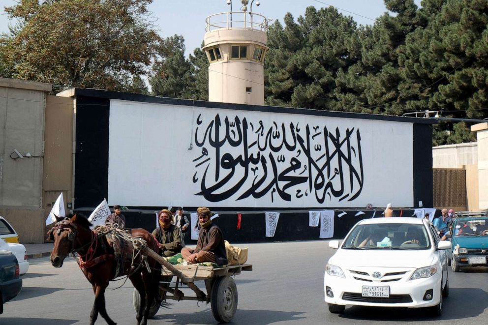 PHOTO: In this Sept. 22, 2021, file photo, a horse-drawn cart is seen outside the ex-US embassy where the Taliban flag has been painting on a wall, in Kabul, Afghanistan.