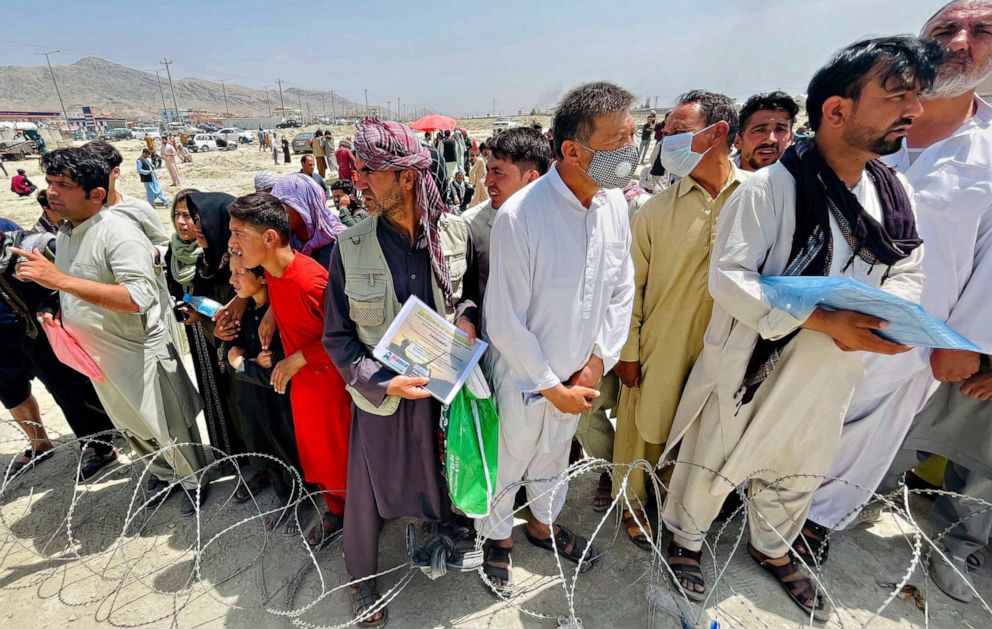 PHOTO: A man holds a certificate acknowledging his work for Americans as hundreds of people gather outside the international airport in Kabul, Tuesday, Aug. 17, 2021.