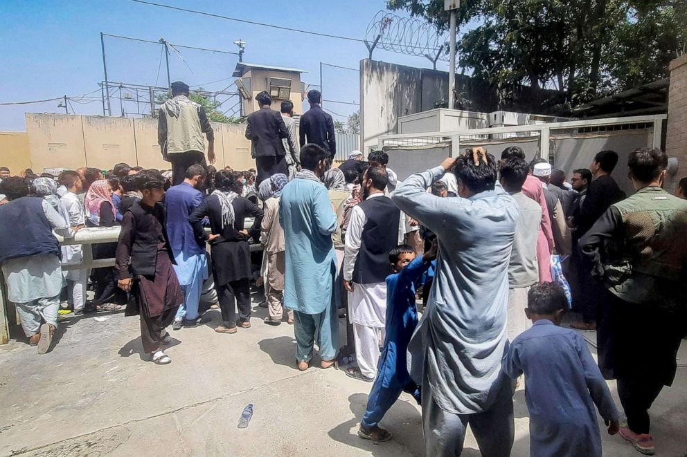 PHOTO: Afghan people gather outside the French embassy in Kabul on August 17, 2021 waiting to leave Afghanistan.