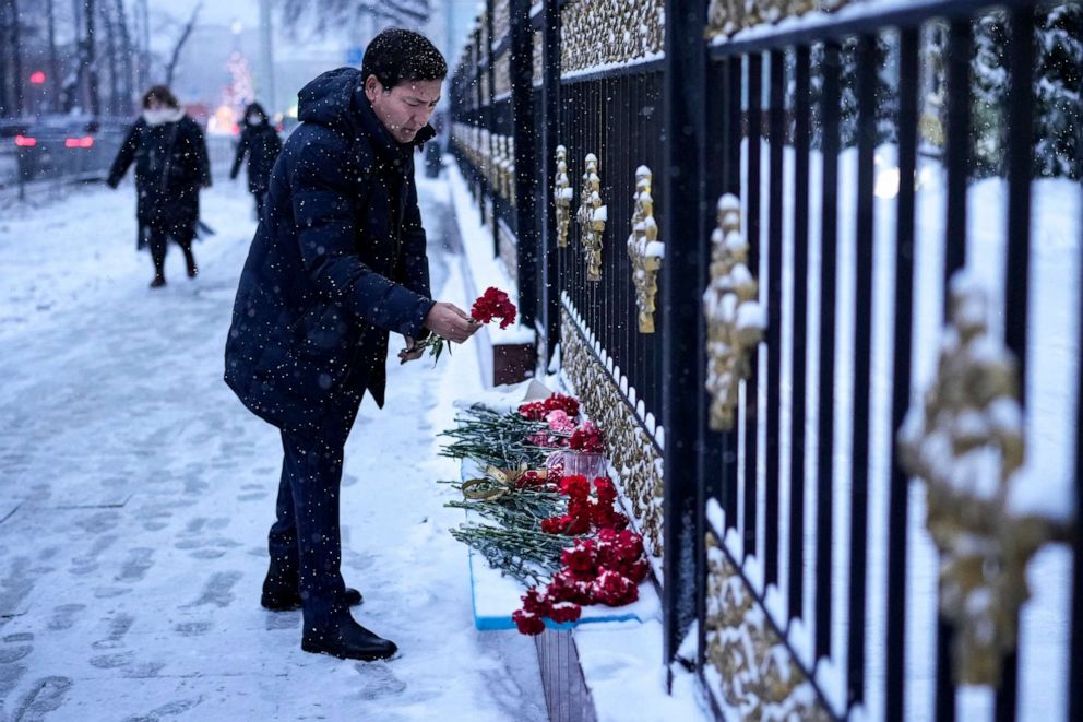 PHOTO: A man lays flowers in memory of victims in recent protests at the fence of the Kazakhstan Embassy in Moscow, Jan. 10, 2022.