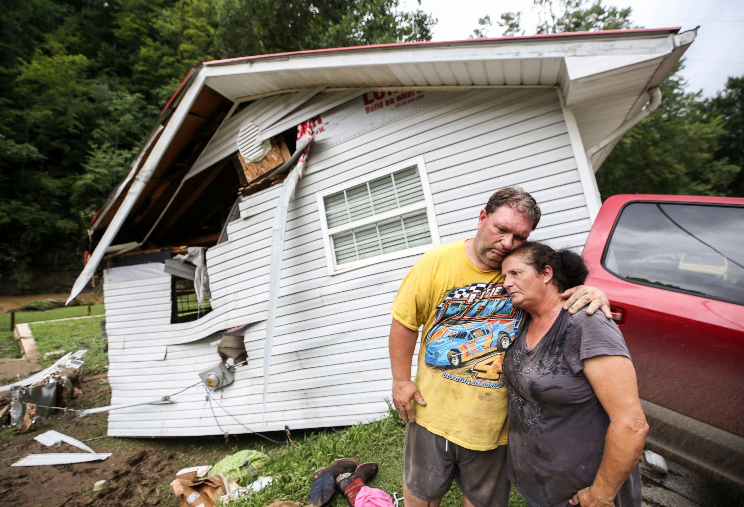 PHOTO: Reggie Ritchie comforts wife Della as they pause while clearing out their destroyed manufactured home destroyed by the flooding from Troublesome Creek behind them in Fisty, Ky., on July 29, 2022.