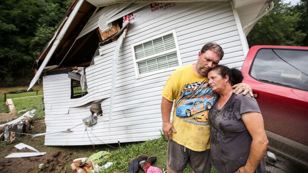 PHOTO: Reggie Ritchie comforts wife Della as they pause while clearing out their destroyed manufactured home destroyed by the flooding from Troublesome Creek behind them in Fisty, Ky., on July 29, 2022.