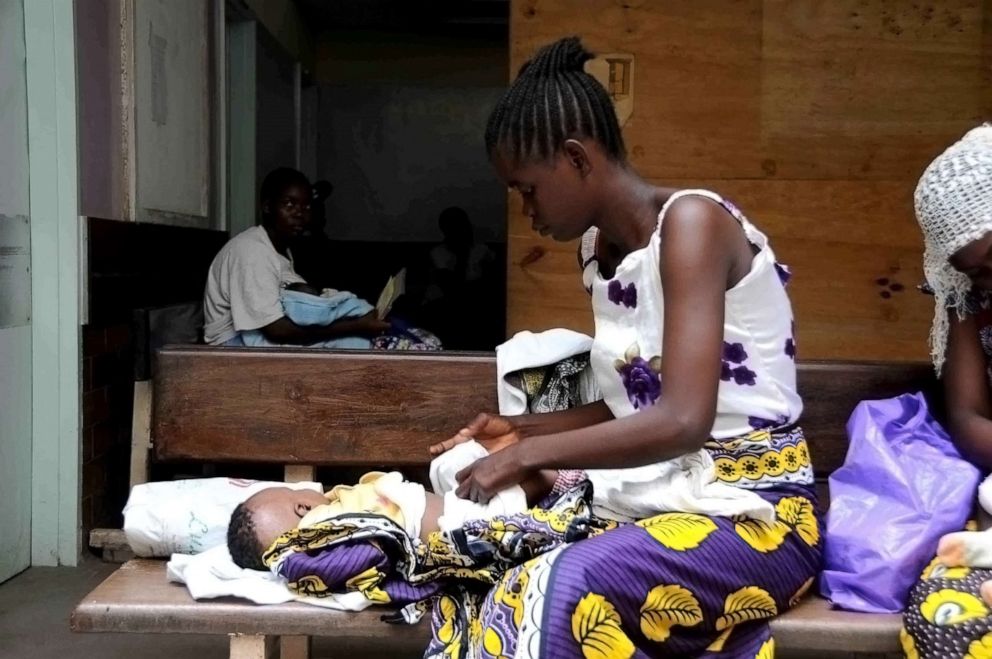 PHOTO: A mother changes her baby as she waits for medical attention at a clinic in Kenya.