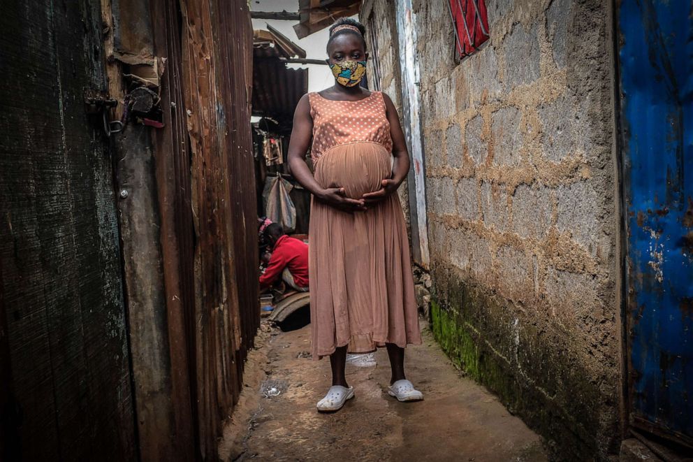 PHOTO: NA young mother holds her eight months baby bump in the Kibera slums of Nairobi, Kenya, June 25, 2020.