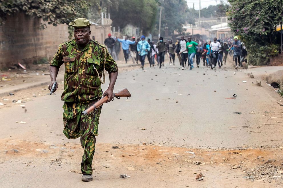 PHOTO: A Kenya Police Officer runs away from a group of opposition supporters chasing him and throwing stones during anti-government protests in Nairobi on July 19, 2023.