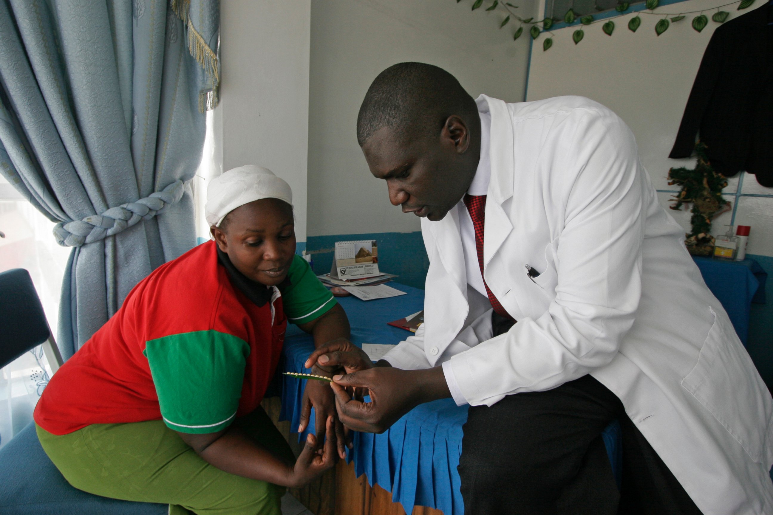 Dr. Aron Sikuku explains family planning pills to Beatrice Ravonga in Nairobi, Kenya. President Donald Trump's move a year ago to expand cuts in U.S. funding to foreign organizations providing abortion has left women without access to treatment.