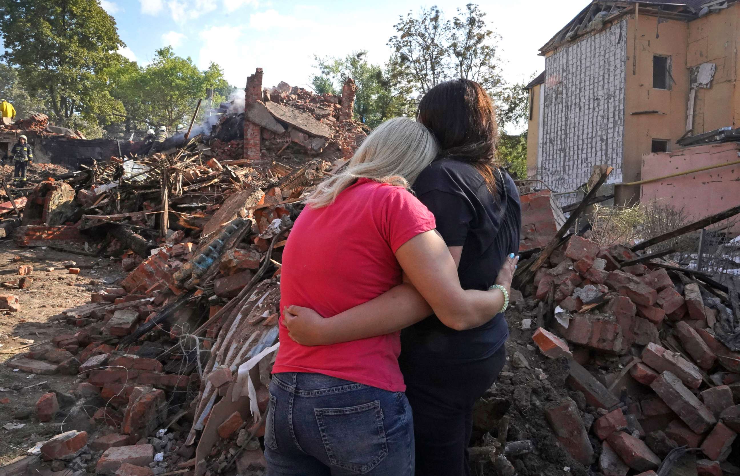PHOTO: Ukrainian women hug in front of a building destroyed during a missile strike in Kharkiv, Ukraine, Aug. 18, 2022.