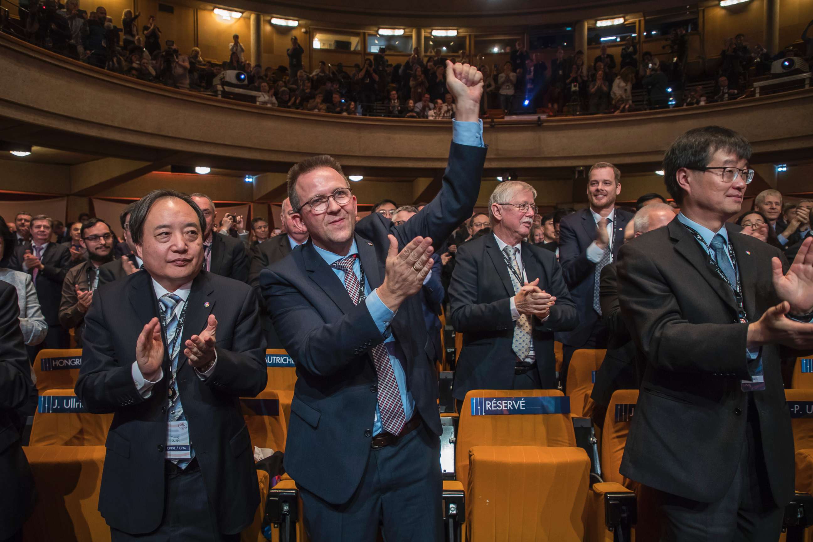 PHOTO: Dutch CIPM member Gert Rietveld and International representatives applause after the final vote introducing the reform during the International General Conference of Weights and Measures held in Versailles, near Paris, France, Nov. 16, 2018.