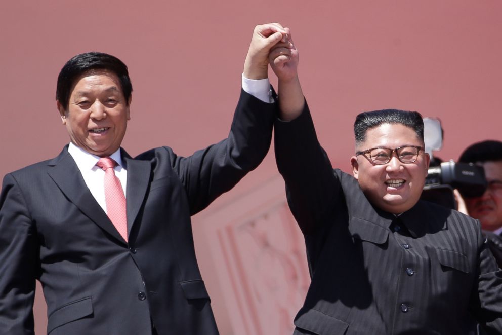 PHOTO: North Korean leader Kim Jong Un, right, raises hands with China's third highest ranking official, Li Zhanshu, during a parade for the 70th anniversary of North Korea's founding day in Pyongyang, North Korea, Sept. 9, 2018.