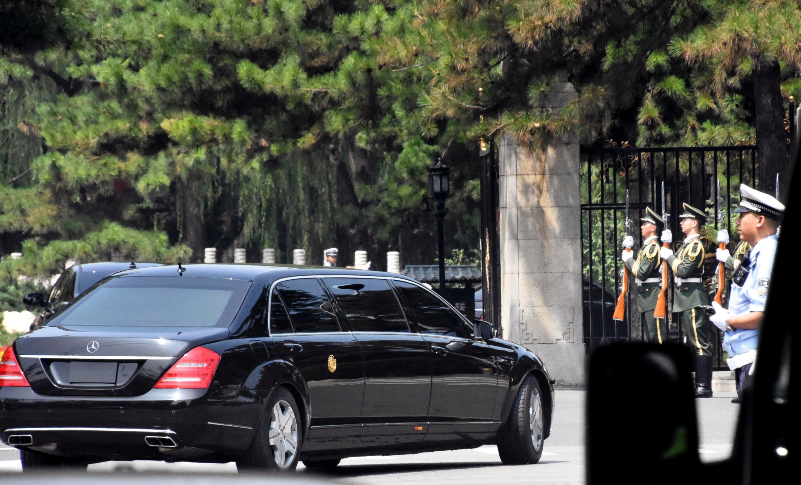 A stretch limousine with a golden emblem similar to one North Korean leader Kim Jong Un has used previously, arrives with motorcycle escorts and guard of honor salute at the Diaoyutai State Guest house in Beijing, China, Tuesday, June 19, 2018.