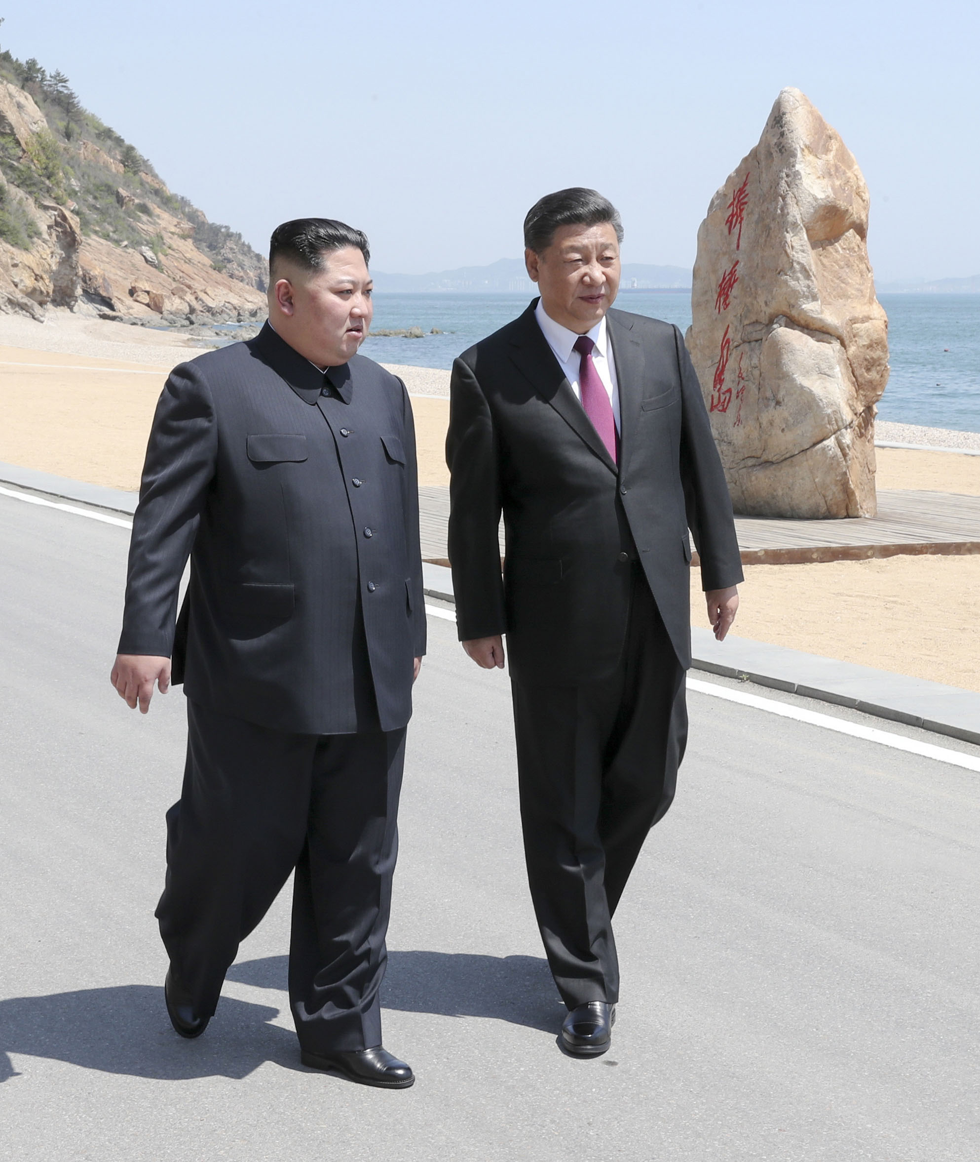 PHOTO: North Korean leader Kim Jong Un and Chinese President Xi Jinping walk during a meeting in Dalian in northeastern China's Liaoning Province.